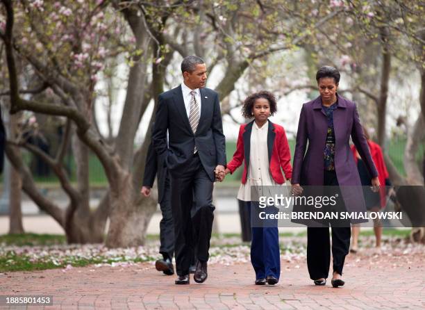 President Barack Obama and first lady Michelle Obama walk through Lafayette Square with their daughter Sasha to Sunday service at St. John's Church...