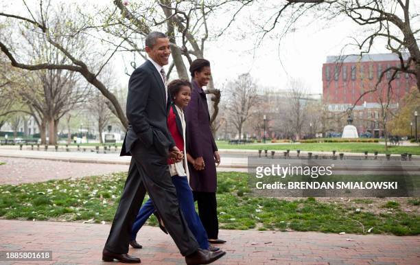 President Barack Obama and first lady Michelle Obama walk through Lafayette Square with their daughter Sasha to Sunday service at St. John's Church...