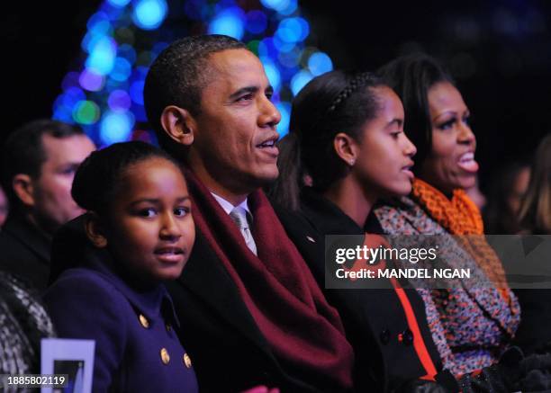 President Barack Obama and First Lady Michelle Obama and their daughters Malia and Sasha sing "Rudolf the Red Nose Reindeer" during the annual...