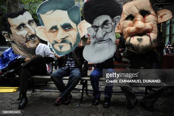 Demonstrators hold effigies of Iranian President Mahmoud Ahmadinejad, Syrian President Bashar al-Assad and Iran's religiuous leader Ayatollah Ali...