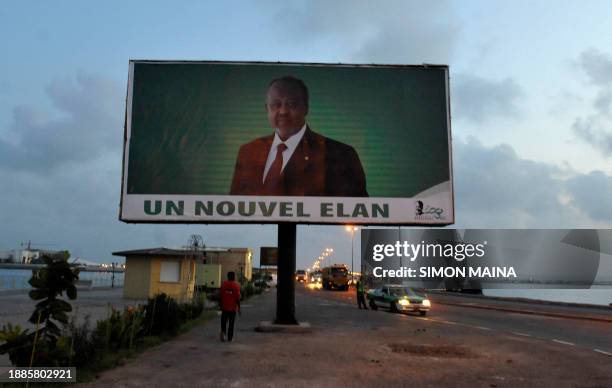 Djiboutians walk past a billboard showing President Ismael Omar Guelleh on the street ahead of April 5, 2011 ahead of presidential elections on April...