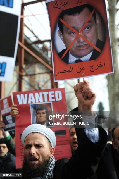 Turkish Muslims carry portraits of Egyptian President Hosni Mubarak on January 28, 2011 during a protest against his regime at Fatih Mosque in...