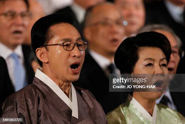 South Korea President Lee Myung-bak and his wife Kim Yoon-ok sing the national anthem during the 92nd anniversary of the 1919 March 1 Independence...
