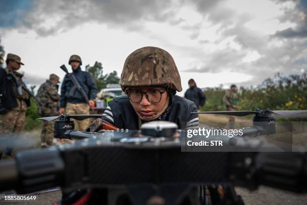 This photo taken on December 11, 2023 shows a member of the Mandalay People's Defense Forces preparing to release a drone near the frontline amid...