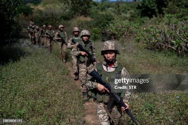 This photo taken on December 10, 2023 shows members of the Mandalay People's Defense Forces patrolling near the frontline amid clashes with Myanmar's...