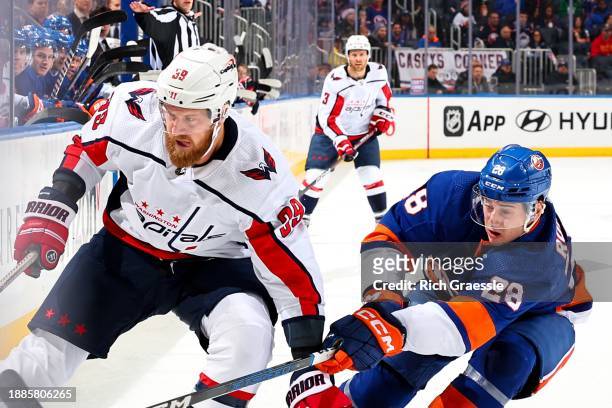 Anthony Mantha of the Washington Capitals battles Alexander Romanov of the New York Islanders on December 29, 2023 at UBS Arena in Hempstead, New...