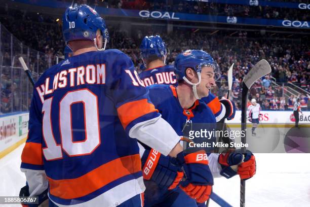 Julien Gauthier of the New York Islanders is congratulated by Simon Holmstrom and Samuel Bolduc during the third period at UBS Arena on December 29,...