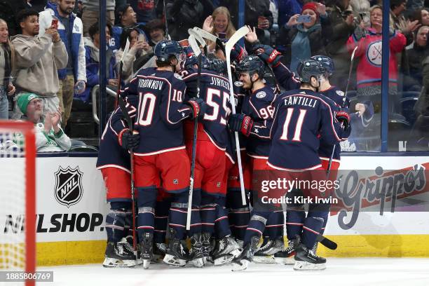 Johnny Gaudreau of the Columbus Blue Jackets is congratulated by his teammates after scoring the game winning against the Toronto Maple Leafs during...