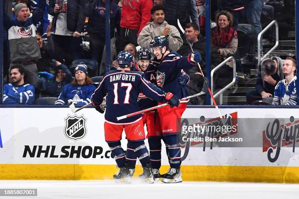 Johnny Gaudreau of the Columbus Blue Jackets celebrates his game-winning overtime goal with teammates Justin Danforth and Damon Severson of the...