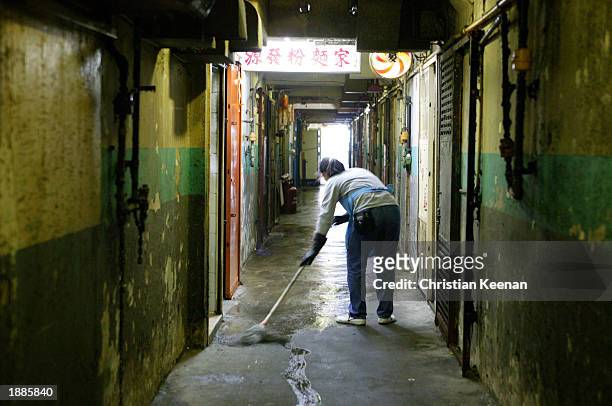 Cleaner mops the floor of a housing complex with disinfectant March 30, 2003 in Hong Kong. Hong Kong officials have announced a day of cleaning to...