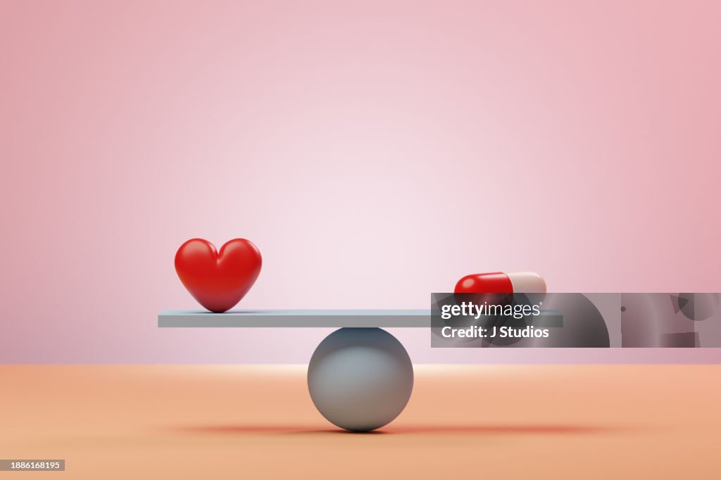 Oversized pill next to red heart