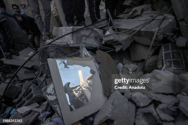 Residents and civil defense teams carry out a search and rescue operation around the rubble of the building after Israeli attacks on the house...