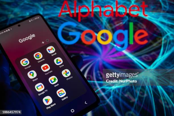 Google apps such as Gmail, Drive, Play Store, Maps, and Chrome are being displayed on a smartphone with Google Alphabet visible in the background, in...