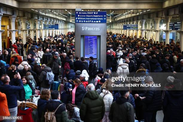 Passengers wait for news of Eurostar departures at St Pancras station in London on December 30 as services are disrupted due to flooding. Eurostar...