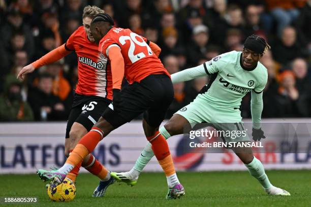 Chelsea's English striker Noni Madueke vies with Luton Town's English midfielder Alfie Doughty and Luton Town's Jamaican defender Amari'i Bell during...