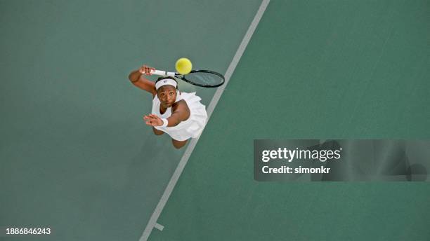 tennis player playing in tennis court - taking a shot sport stock pictures, royalty-free photos & images
