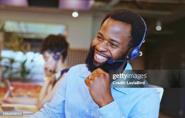 close-up of bearded consultant wearing headset listening cheerfully to customer in call center - callcenter bildbanksfoton och bilder