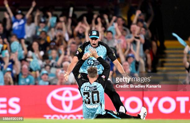 Matthew Kuhnemann of the Heat celebrates with team mate Xavier Bartlett after taking the catch to dismiss Oliver Davies of the Thunder during the BBL...