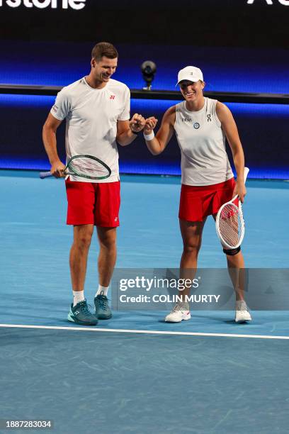 Poland's Hubert Hurkacz and Iga Swiatek gesture as they compete against Brazil's Marcelo Melo and Beatriz Haddad Maia during their mixed doubles...