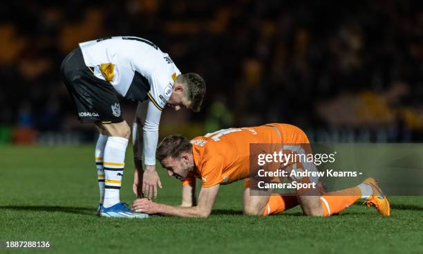 Blackpool's Jordan Rhodes is helped up by Port Vale's Alfie Devine during the Sky Bet League One match between Port Vale and Blackpool at Vale Park...