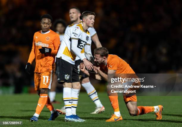 Blackpool's Jordan Rhodes is helped to his feet by Port Vale's Alfie Devine during the Sky Bet League One match between Port Vale and Blackpool at...