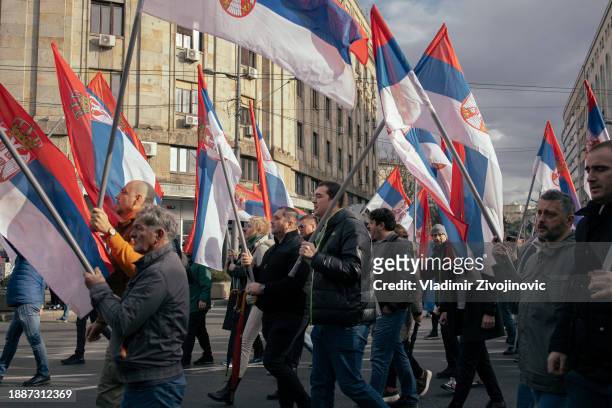 People wave Serbian flags, as they attend a protest organised by ProGlas on December 30, 2023 in Belgrade, Serbia. Anti-government protests have...