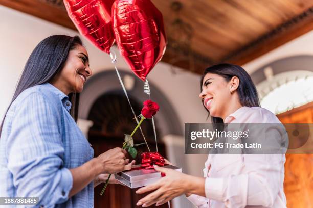 lesbian woman being gifted by her girlfriend - gay couple in love stock pictures, royalty-free photos & images