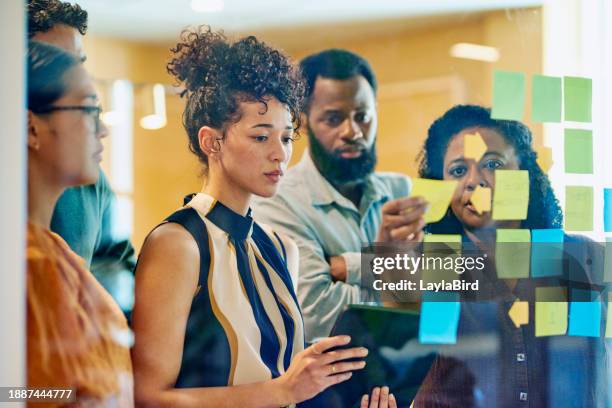 diverse professionals brainstorming on glass wall - social justice concept stockfoto's en -beelden