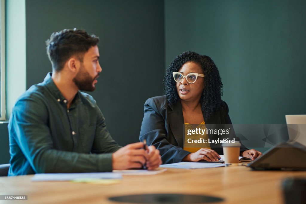 Two business professionals having a meeting in an office discussing ideas and strategies