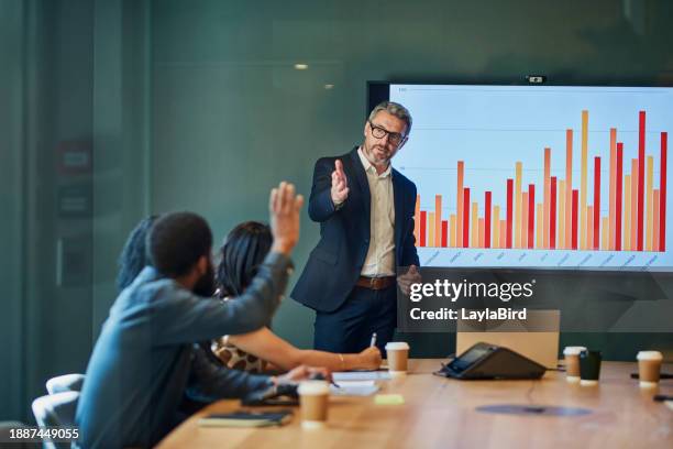 business professionals in a meeting brainstorming ideas and discussing financial data and statistics - revenue stock pictures, royalty-free photos & images