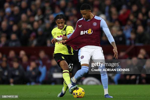 Aston Villa's English defender Ezri Konsa has his shirt pulled by Burnley's French striker Wilson Odobert during the English Premier League football...