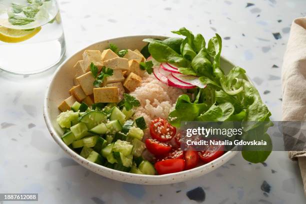 vegan vegetarian salad buddha bowl - rice, tofu, cherry tomato, cucumber, radish, lettuce - cashew pieces stock pictures, royalty-free photos & images