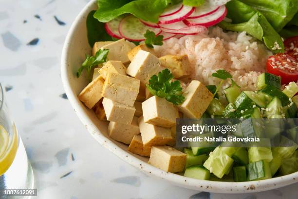 vegan vegetarian salad buddha bowl - rice, tofu, cherry tomato, cucumber, radish, lettuce - cashew pieces stock pictures, royalty-free photos & images