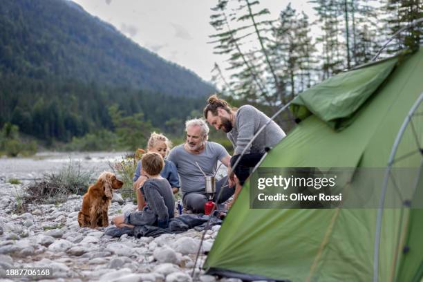 family with dog camping in rural landscape - multi generational family with pet stock pictures, royalty-free photos & images