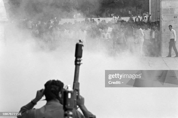 An Israeli soldier holds a tear gas grenade launcher facing Palestinians as they clash at the Al-Aqsa mosque compound in East Jerusalem on October 11...