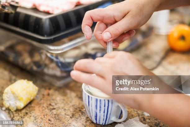 woman hands filling syringe with milk formula from the cup - adult eating no face stock pictures, royalty-free photos & images