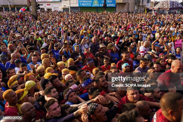 The crowd is seen trying to reach the statue of San Benito during the procession. The San Benito festival is celebrated in Cabimas within the Zulia...