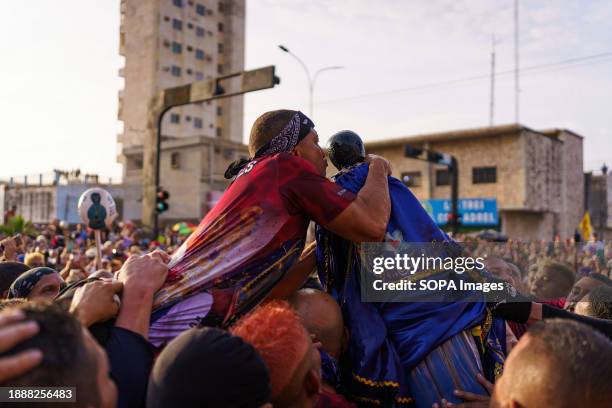 Man is seen kissing the statue of San Benito during the procession. The San Benito festival is celebrated in Cabimas within the Zulia state every...