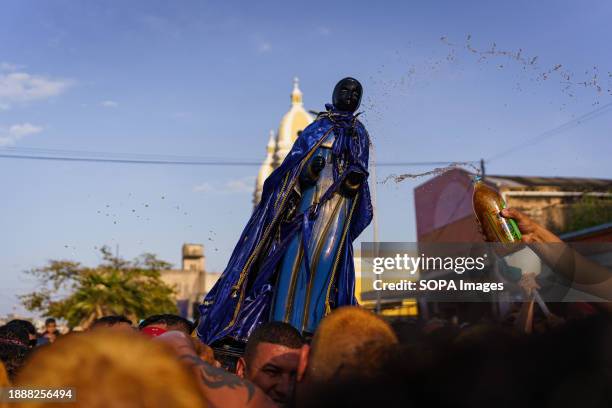 The crowd is seen touching the statue of San Benito as a sign of devotion during the procession. The San Benito festival is celebrated in Cabimas...