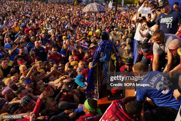 The crowd is seen trying to reach the statue of San Benito during the procession. The San Benito festival is celebrated in Cabimas within the Zulia...