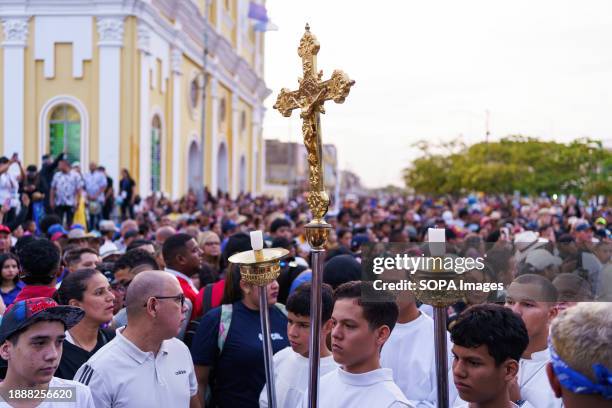 Cross is seen in the crowd during the procession. The San Benito festival is celebrated in Cabimas within the Zulia state every December 27th. The...