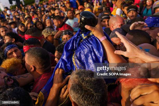 Devotees are seen touching the statue of San Benito during the procession. The San Benito festival is celebrated in Cabimas within the Zulia state...