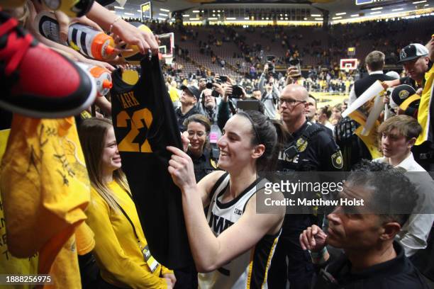 Guard Caitlin Clark of the Iowa Hawkeyes signs autographs after the match-up against the Minnesota Gophers at Carver-Hawkeye Arena on December 30,...