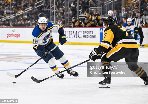 St. Louis Blues center Robert Thomas skates with the puck in front of Pittsburgh Penguins defenseman John Ludvig during the second period in the NHL...