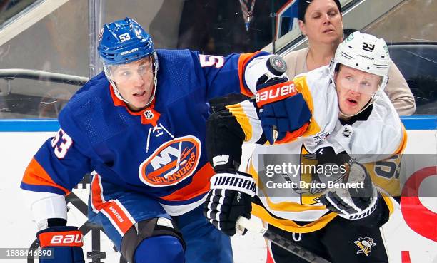 Casey Cizikas of the New York Islanders battles with Jake Guentzel of the Pittsburgh Penguins during the first period at UBS Arena on December 27,...