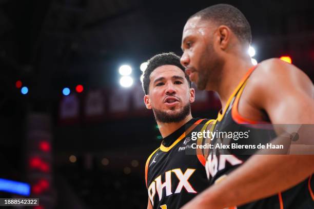 Devin Booker and Eric Gordon of the Phoenix Suns talk as they walk off the court after the end of the first half of the game against the Houston...