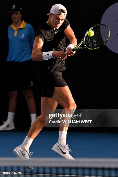 Denmark's Holger Rune hits a return during his men's doubles match with partner Andy Murray of Britain against Russian duo Aslan Karatsev and Roman...