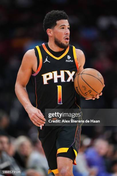 Devin Booker of the Phoenix Suns dribbles the ball during the first half of the game against the Houston Rockets at Toyota Center on December 27,...