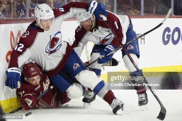 Troy Stecher of the Arizona Coyotes attempts to play the puck after a check from Josh Manson of the Colorado Avalanche during the second period of...