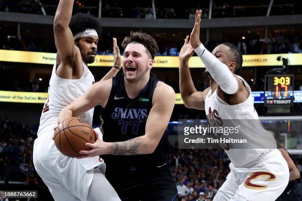 Luka Doncic of the Dallas Mavericks drives to the basket against Jarrett Allen of the Cleveland Cavaliers and Isaac Okoro of the Cleveland Cavaliers...